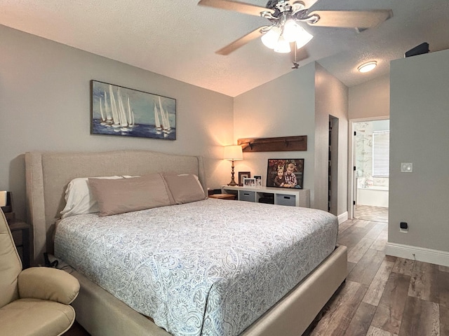 6446 Terra Rosa Cir, Boynton Beach, FL 33472 - bedroom featuring dark wood-type flooring, lofted ceiling, baseboards, a textured ceiling, and ensuite bathroom