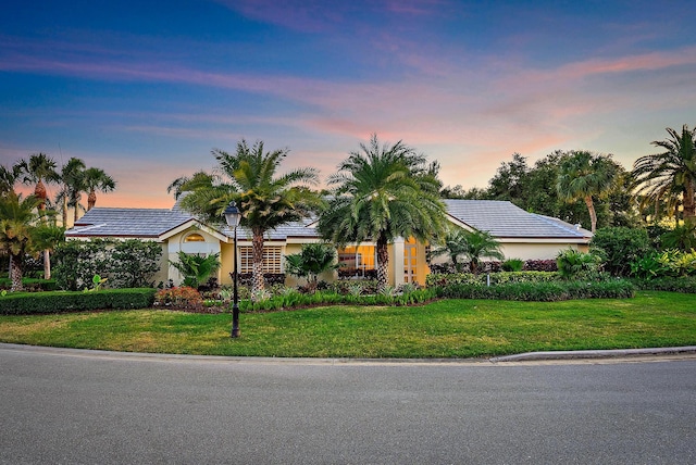 ranch-style house with a lawn and stucco siding
