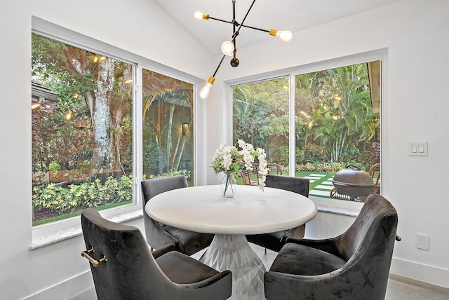 dining area featuring baseboards and lofted ceiling