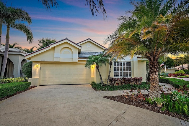 view of front of house featuring a garage, stucco siding, and driveway
