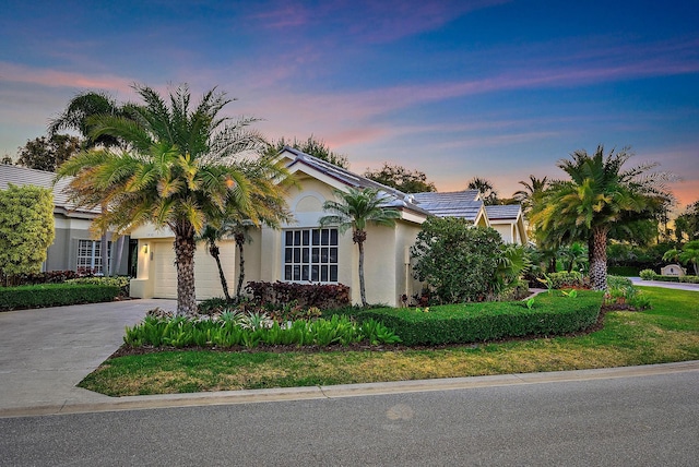 view of front of house featuring concrete driveway, an attached garage, and stucco siding