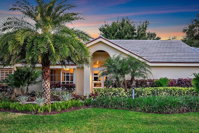 single story home featuring a front yard and stucco siding