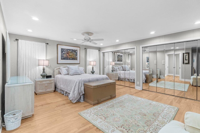 bedroom featuring recessed lighting, ceiling fan, two closets, and light wood-type flooring