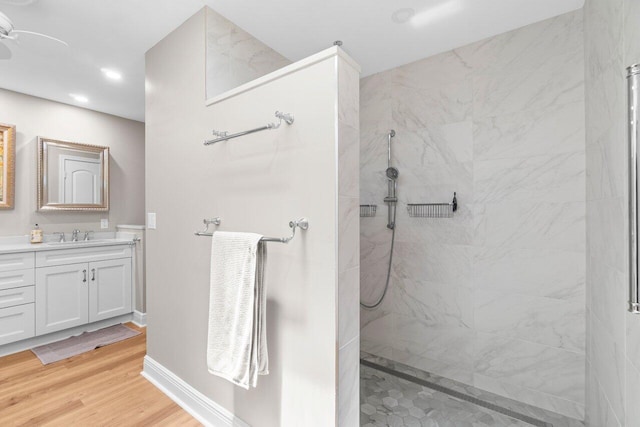 bathroom with recessed lighting, walk in shower, wood finished floors, and vanity