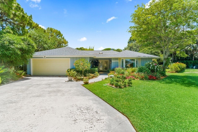 ranch-style house featuring a front yard, french doors, board and batten siding, concrete driveway, and an attached garage