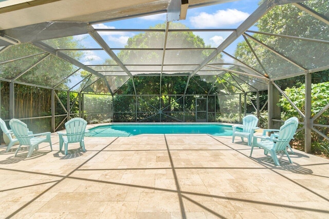 pool featuring glass enclosure and a patio area