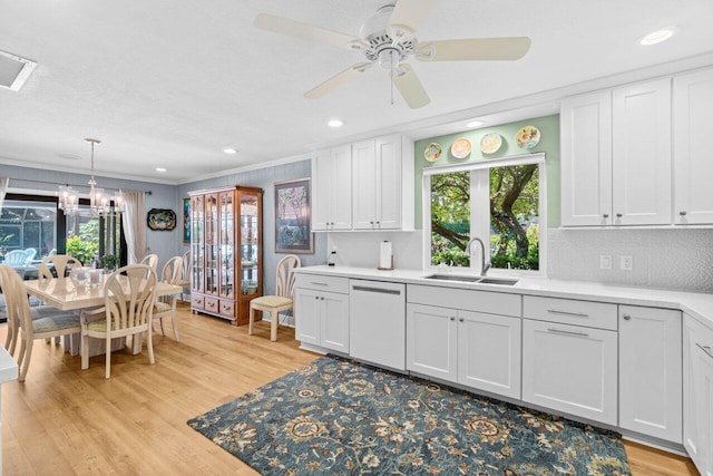 kitchen with a sink, white dishwasher, plenty of natural light, and light wood-style flooring