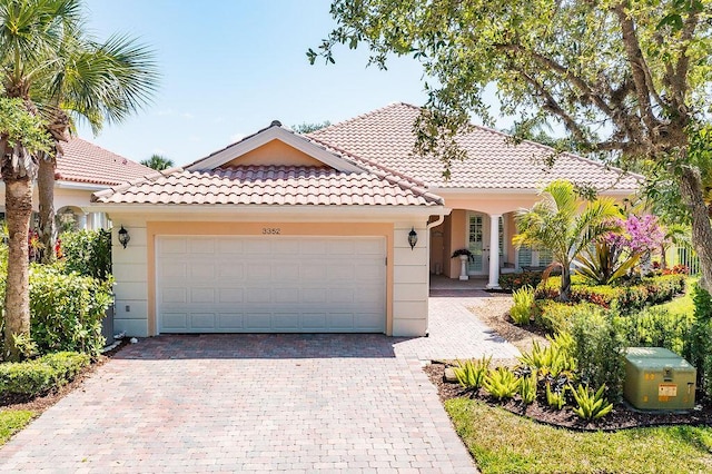 3352 SE Cascadia Way, Hobe Sound, FL 33455 - mediterranean / spanish home with a garage, a tiled roof, and decorative driveway