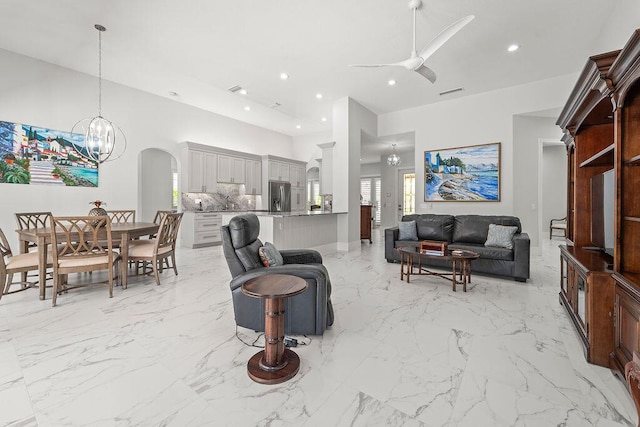 3352 SE Cascadia Way, Hobe Sound, FL 33455 - living area with arched walkways, ceiling fan with notable chandelier, recessed lighting, and a towering ceiling