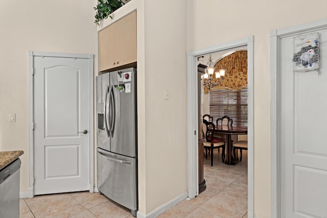 kitchen featuring an inviting chandelier, light tile patterned floors, stainless steel appliances, and baseboards
