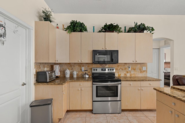 kitchen with a toaster, light tile patterned floors, black microwave, decorative backsplash, and stainless steel range with electric cooktop