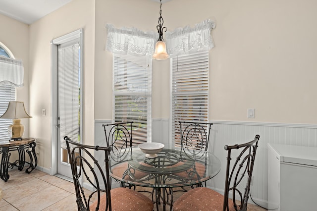 dining room with tile patterned floors and wainscoting