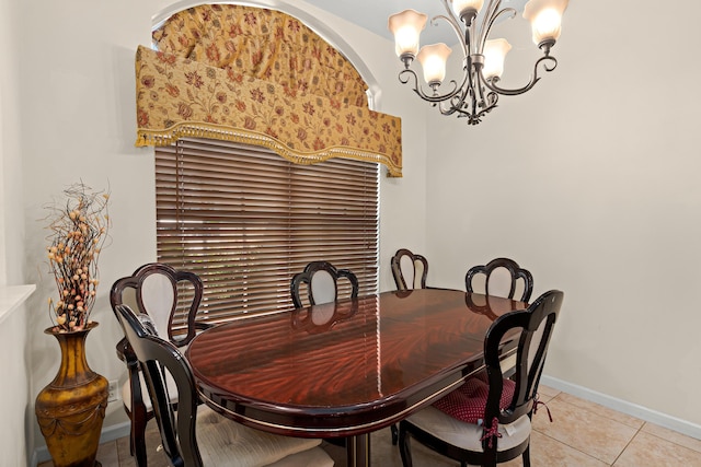 dining area featuring an inviting chandelier, light tile patterned floors, and baseboards