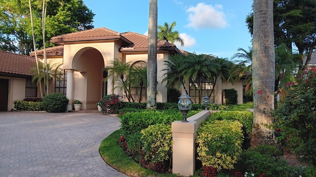 view of front of home featuring decorative driveway, stucco siding, and a tiled roof