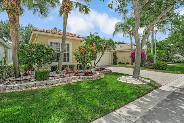 7562 Starfish Reef Ln, Lake Worth, FL 33467 - mediterranean / spanish house featuring driveway, stucco siding, a tiled roof, a front yard, and an attached garage