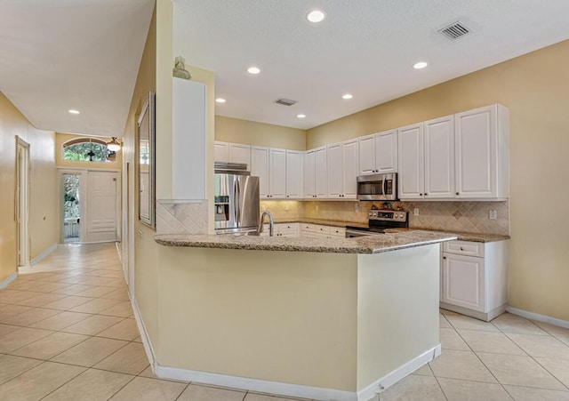 7562 Starfish Reef Ln, Lake Worth, FL 33467 - kitchen with stainless steel appliances, light tile patterned floors, light stone countertops, backsplash, and recessed lighting