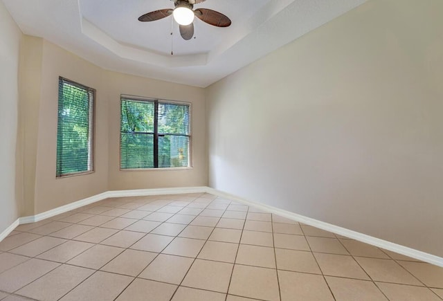 7562 Starfish Reef Ln, Lake Worth, FL 33467 - unfurnished room featuring light tile patterned floors, ceiling fan, baseboards, and a raised ceiling