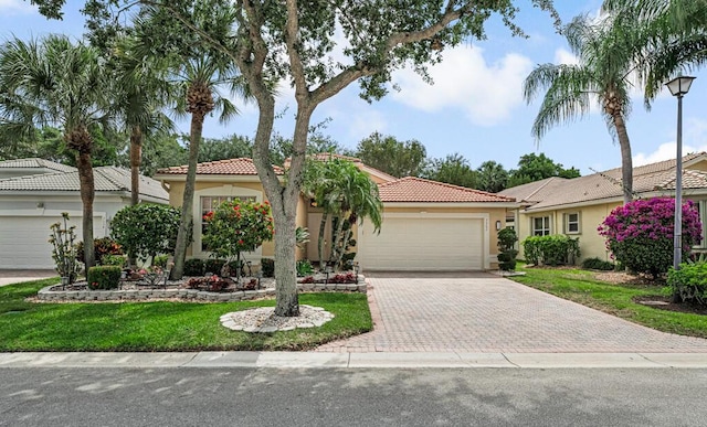 7562 Starfish Reef Ln, Lake Worth, FL 33467 - view of front facade with a tiled roof, stucco siding, a garage, driveway, and a front yard