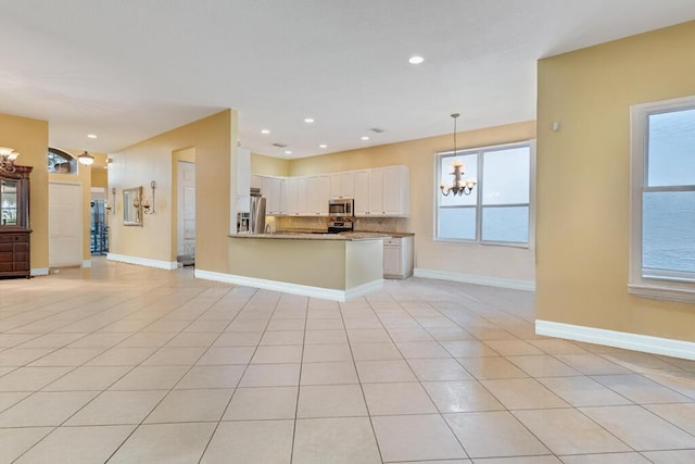 7562 Starfish Reef Ln, Lake Worth, FL 33467 - kitchen with appliances with stainless steel finishes, a chandelier, open floor plan, white cabinetry, and decorative light fixtures