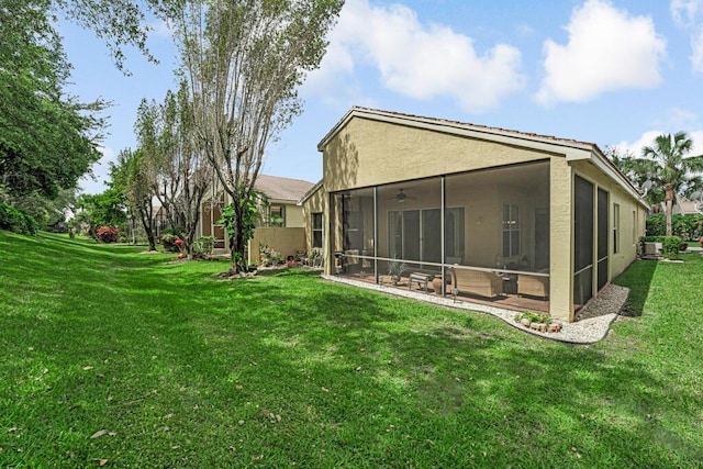 7562 Starfish Reef Ln, Lake Worth, FL 33467 - back of house featuring a sunroom, stucco siding, ceiling fan, and a lawn