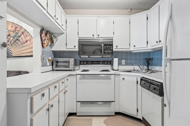 kitchen featuring a toaster, white appliances, light countertops, a sink, and backsplash