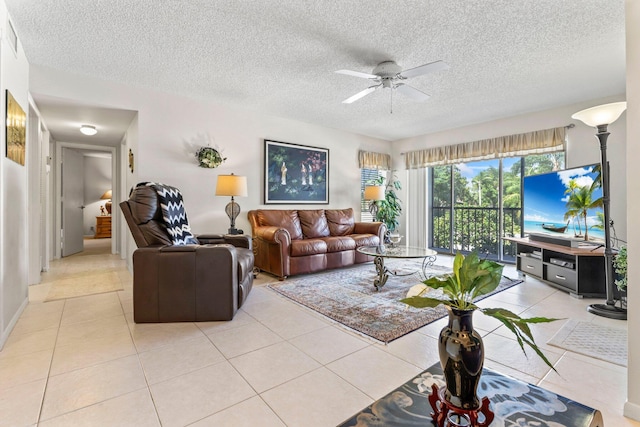 living area with a ceiling fan, a textured ceiling, and light tile patterned flooring
