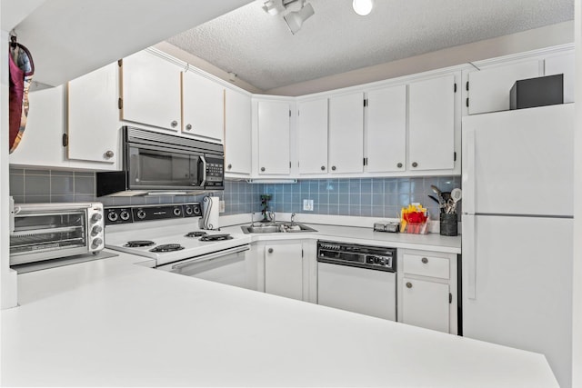 kitchen with white appliances, white cabinetry, a sink, and a toaster