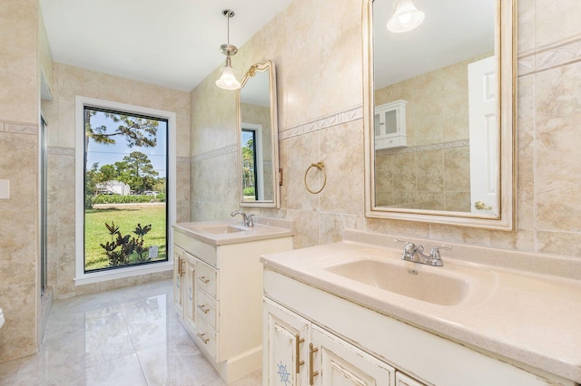 bathroom featuring tile walls, two vanities, and marble finish flooring