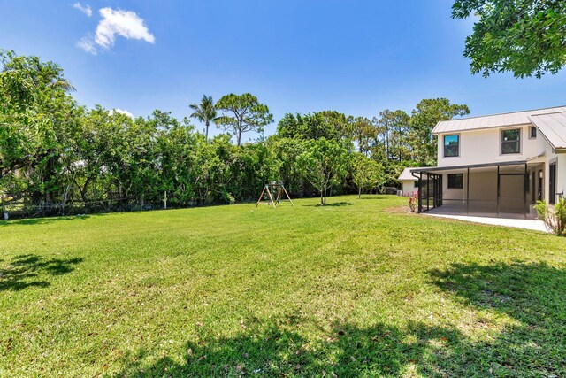 view of grassy yard featuring a sunroom