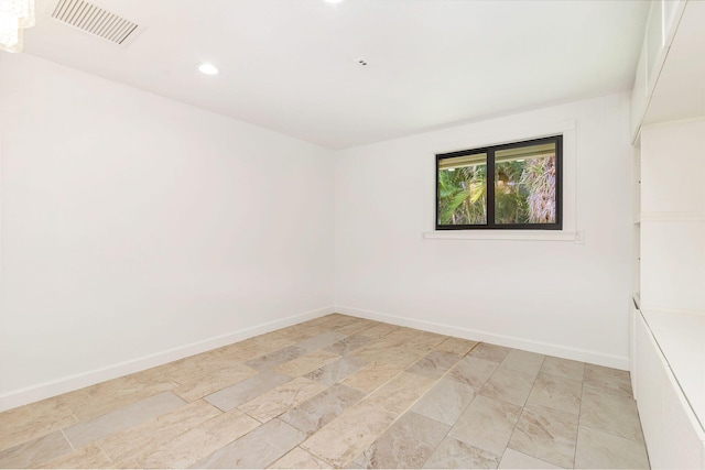 empty room featuring light stone finish flooring, recessed lighting, and baseboards