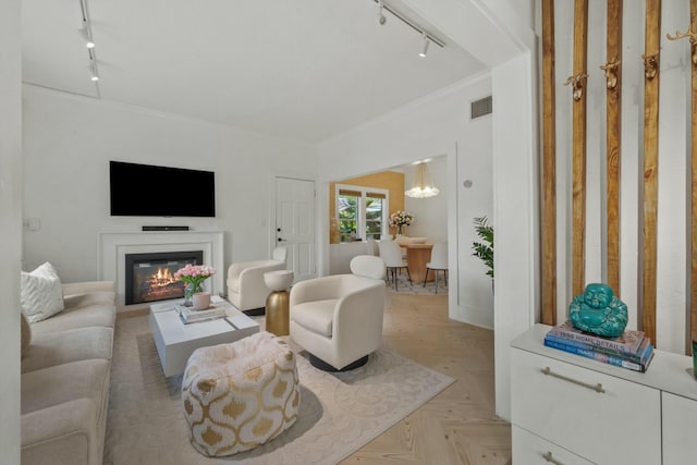 951 Selkirk St, West Palm Beach, FL 33405 - living area featuring visible vents, rail lighting, a glass covered fireplace, and crown molding