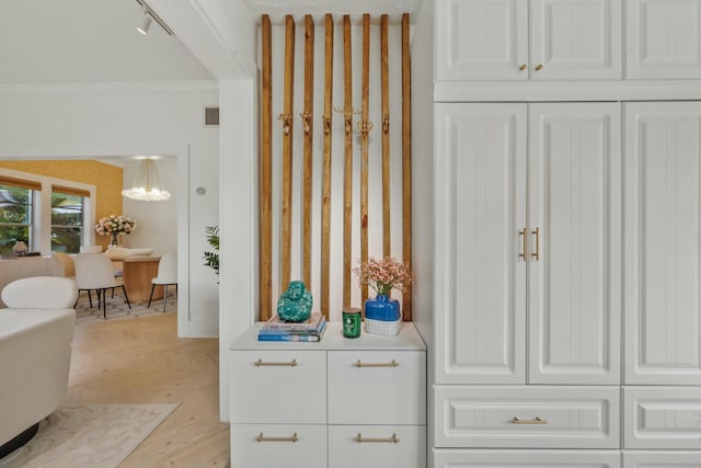 951 Selkirk St, West Palm Beach, FL 33405 - interior space featuring crown molding, a chandelier, rail lighting, and wood finished floors