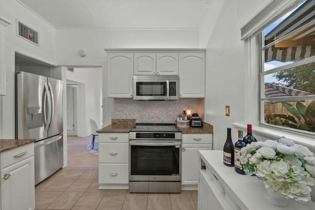 951 Selkirk St, West Palm Beach, FL 33405 - kitchen featuring backsplash, visible vents, white cabinets, dark stone counters, and stainless steel appliances