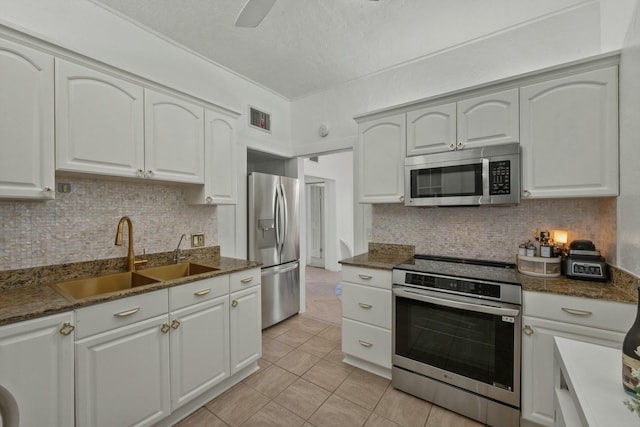 951 Selkirk St, West Palm Beach, FL 33405 - kitchen featuring visible vents, decorative backsplash, a sink, appliances with stainless steel finishes, and light tile patterned floors