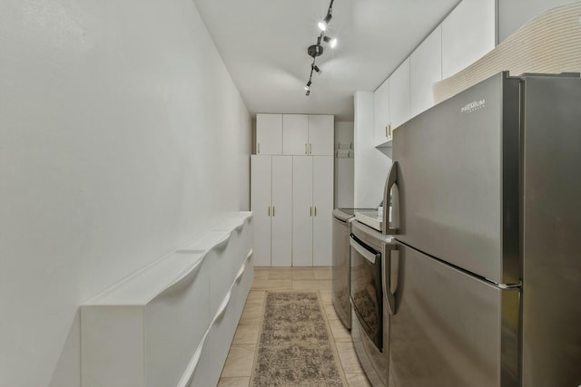 951 Selkirk St, West Palm Beach, FL 33405 - kitchen with white cabinets, light countertops, stove, freestanding refrigerator, and washer / dryer