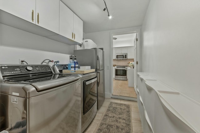 951 Selkirk St, West Palm Beach, FL 33405 - laundry area featuring track lighting, cabinet space, light tile patterned floors, and washing machine and dryer