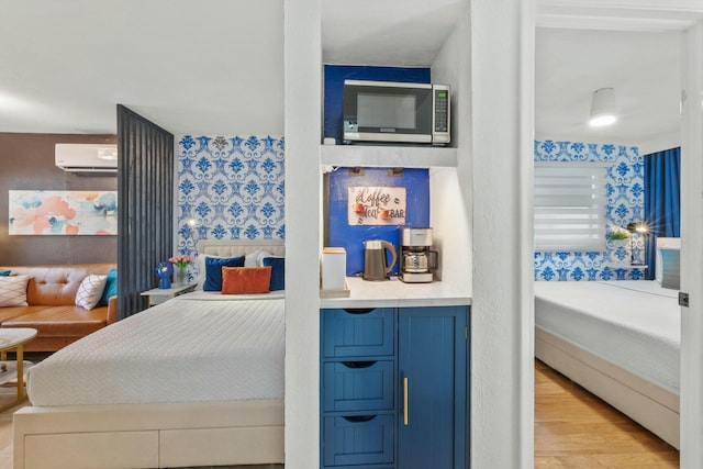 951 Selkirk St, West Palm Beach, FL 33405 - bedroom with light wood finished floors and a wall mounted air conditioner