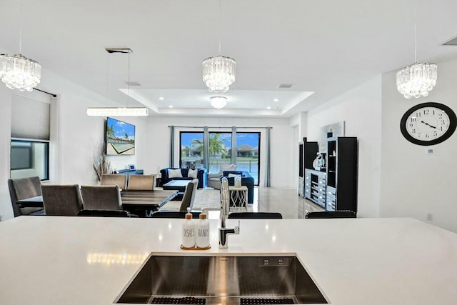12170 N Baypoint Cir, Parkland, FL 33076 - kitchen featuring a chandelier, a raised ceiling, and light countertops