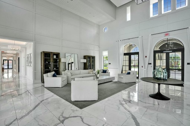 12170 N Baypoint Cir, Parkland, FL 33076 - living room with an inviting chandelier, a towering ceiling, a decorative wall, and marble finish floor