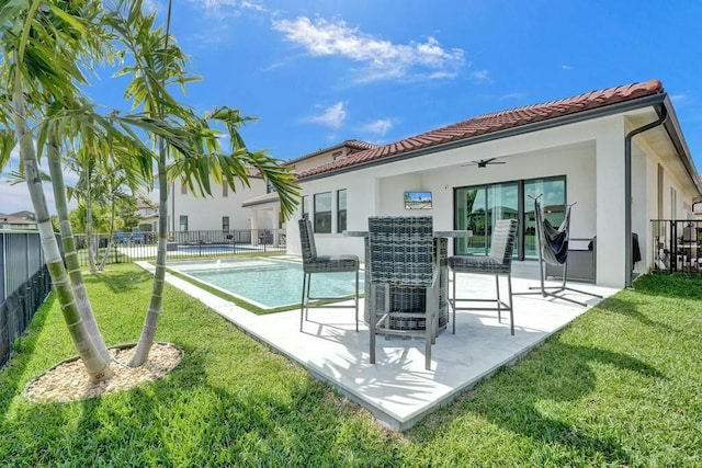 12170 N Baypoint Cir, Parkland, FL 33076 - rear view of property featuring a tile roof, ceiling fan, a yard, and stucco siding