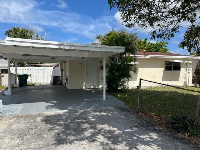 1164 NW 45th Ave, Lauderhill, FL 33313 - exterior space featuring concrete driveway, a carport, stucco siding, and fence