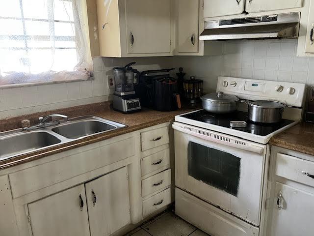 1164 NW 45th Ave, Lauderhill, FL 33313 - kitchen with a sink, under cabinet range hood, decorative backsplash, white electric range, and white cabinetry