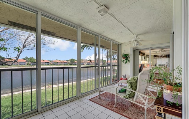 sunroom / solarium featuring a water view, ceiling fan, and a wealth of natural light