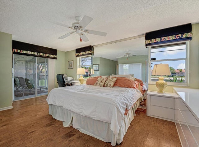 bedroom with ceiling fan, light wood-style flooring, a textured ceiling, and access to exterior