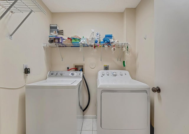 laundry room featuring laundry area, tile patterned flooring, and washing machine and clothes dryer