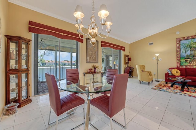 dining space with crown molding, a water view, visible vents, and a chandelier