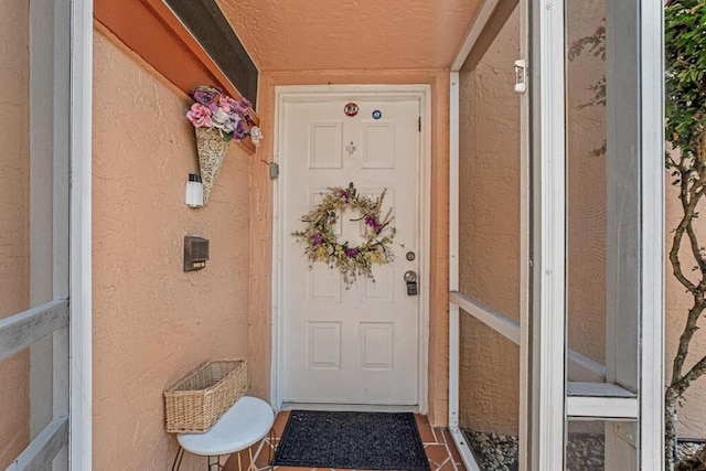 doorway to property featuring stucco siding