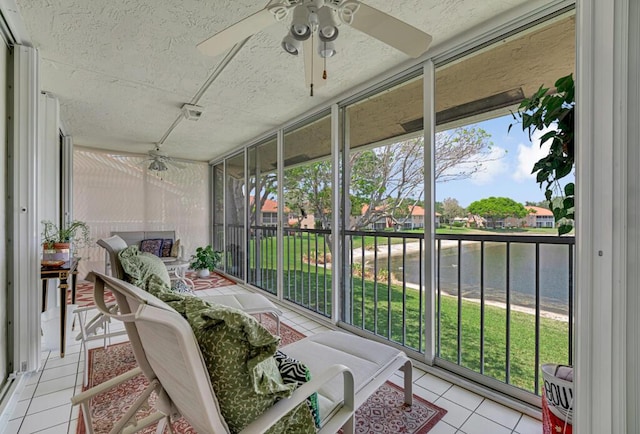 sunroom featuring a water view, ceiling fan, and a wealth of natural light