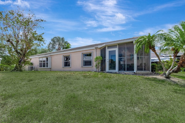back of house featuring a yard, stucco siding, cooling unit, and a sunroom