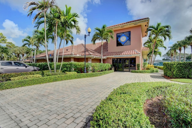 mediterranean / spanish-style home with a tile roof and stucco siding